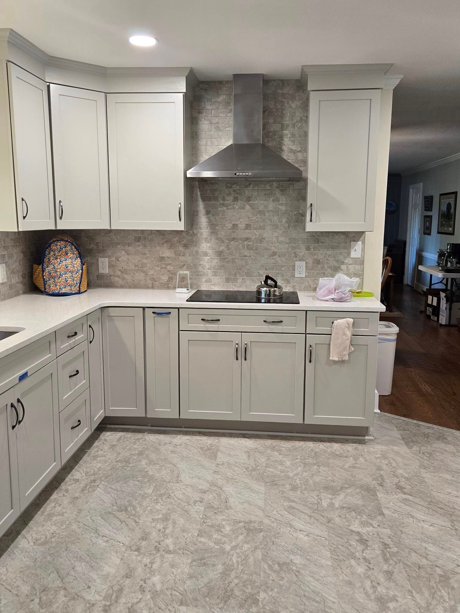 A kitchen with white cabinets and a stove top oven.