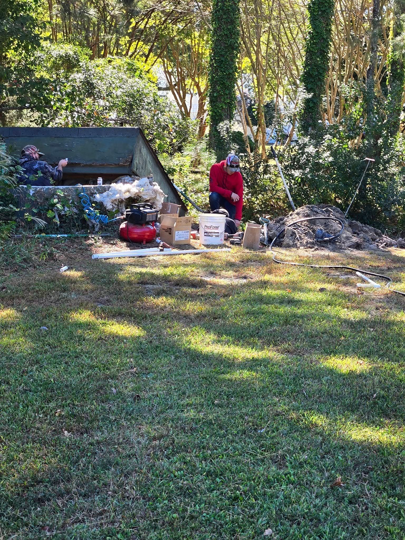 A man is digging in the grass in a yard.