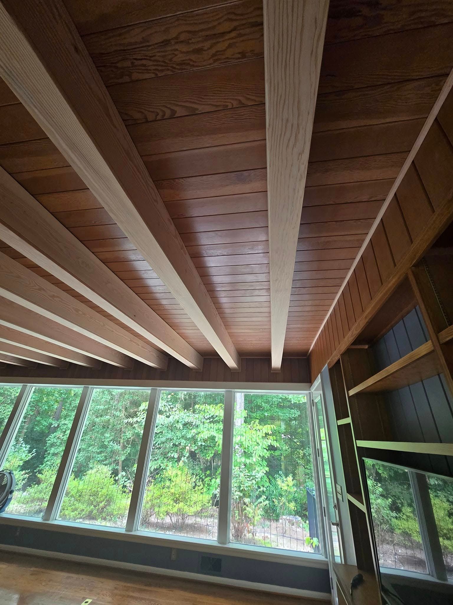 A room with a wooden ceiling and lots of windows.