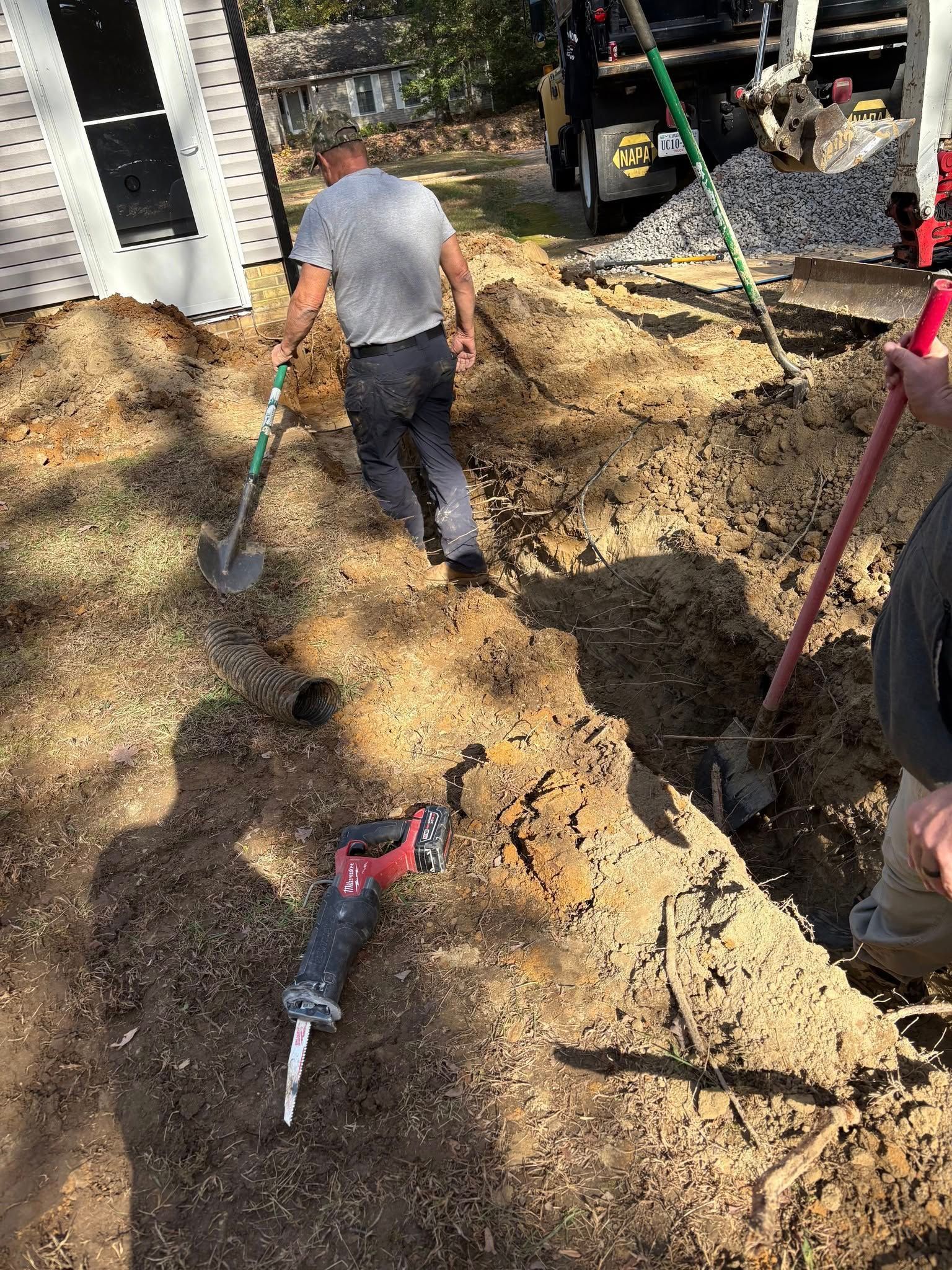 A man is digging a hole in the dirt with a shovel.