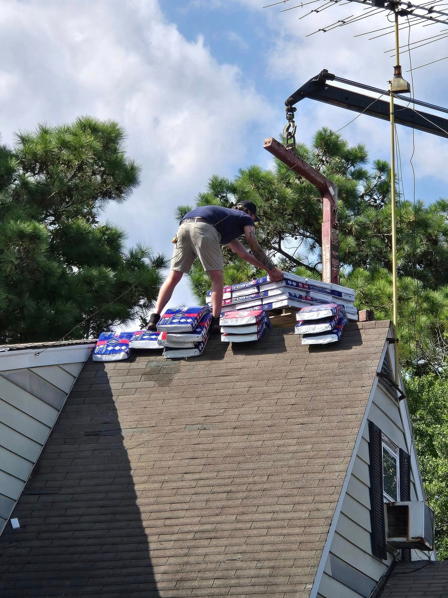A man is working on a roof with a crane