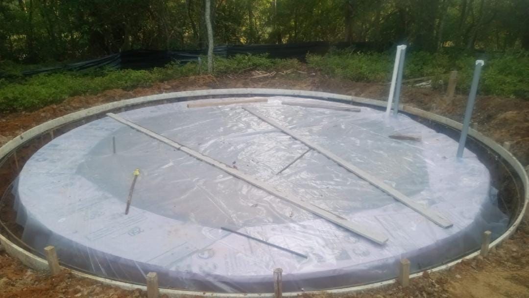 A large concrete circle is being built in the dirt.