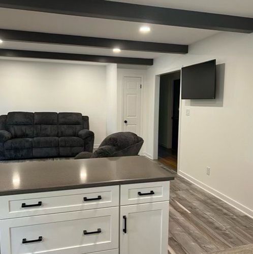 A living room with a couch, chairs, and a flat screen TV.