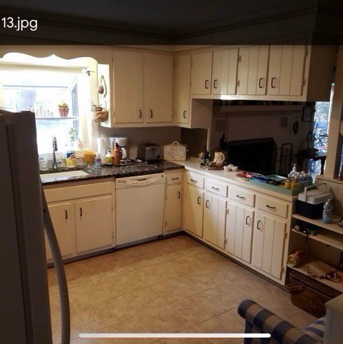 A kitchen with white cabinets and granite counter tops