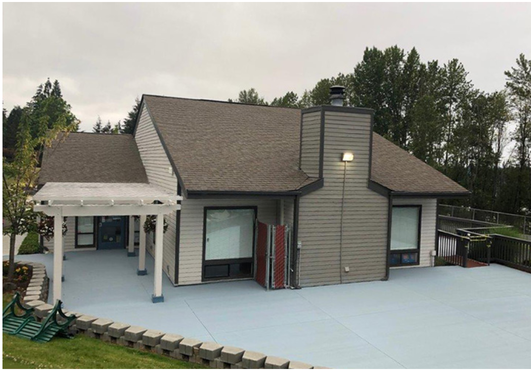 A large house with a blue driveway and a covered porch.