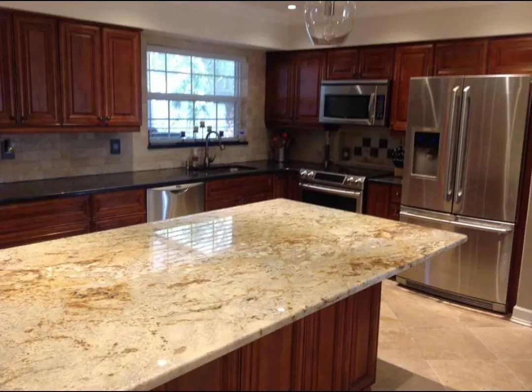 Spacious kitchen with dark wood cabinets, granite island, stainless steel appliances, and a tiled backsplash
