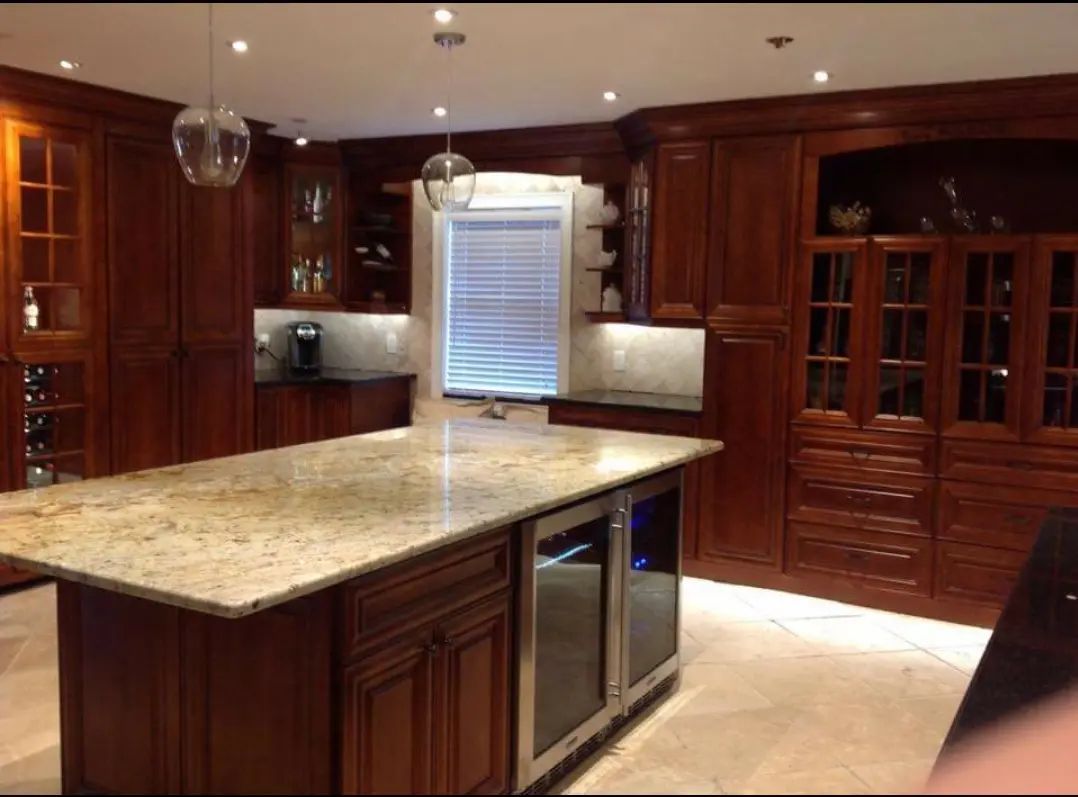 Modern kitchen with dark wood cabinets, granite island, and stainless steel appliances