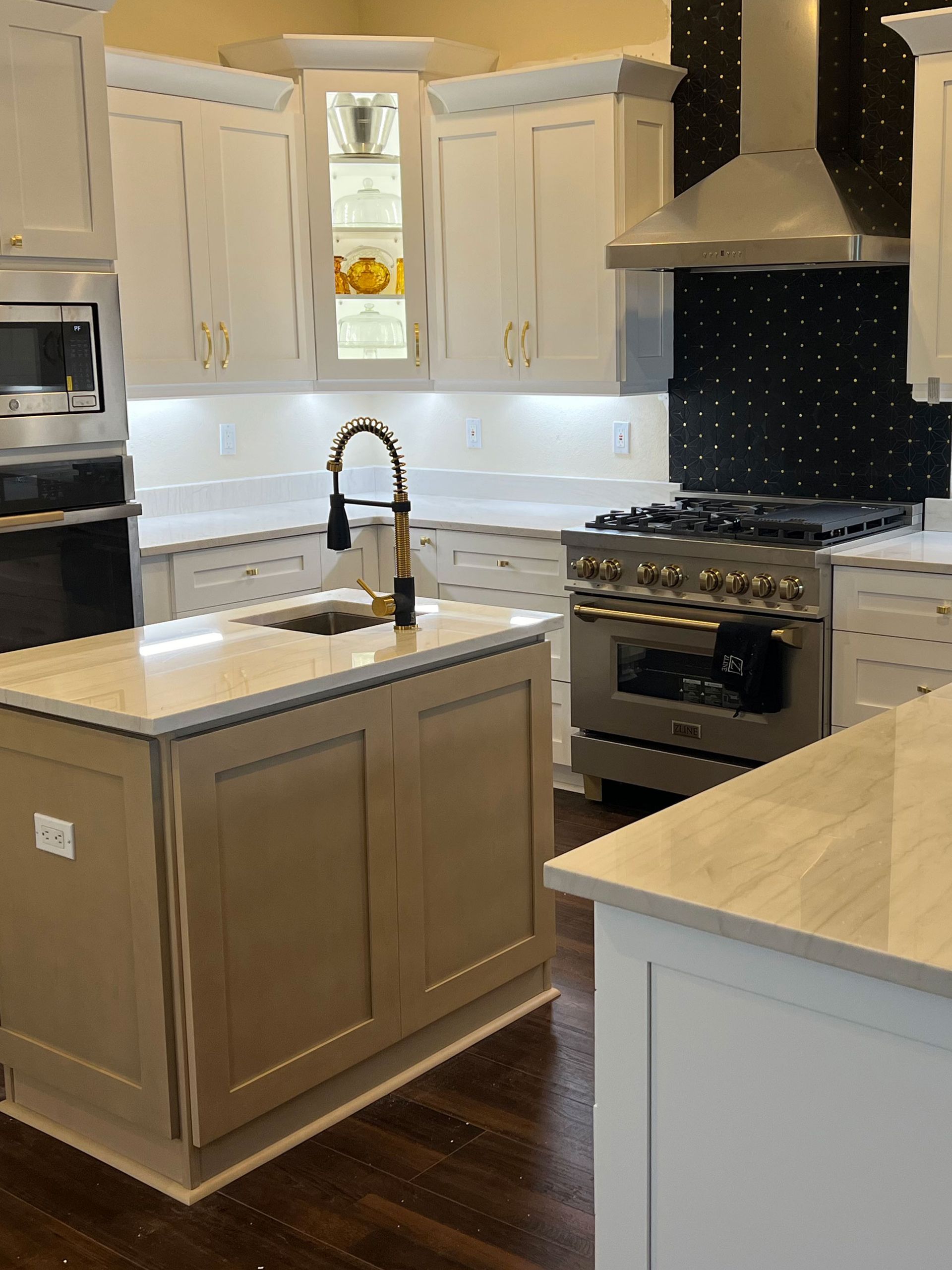 Modern kitchen with white cabinets, dark wood island, stainless stove, and black countertops