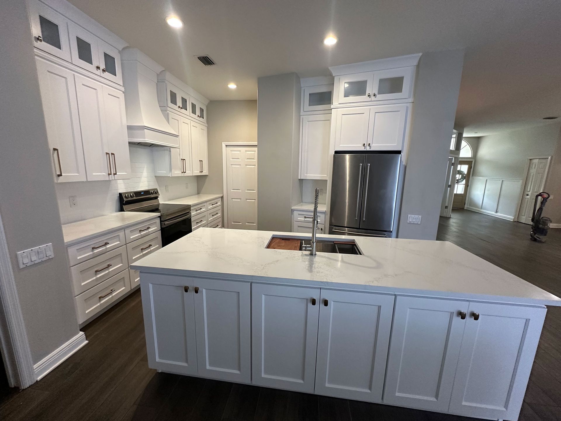 Bright modern kitchen with white cabinets, large island, and stainless steel appliances