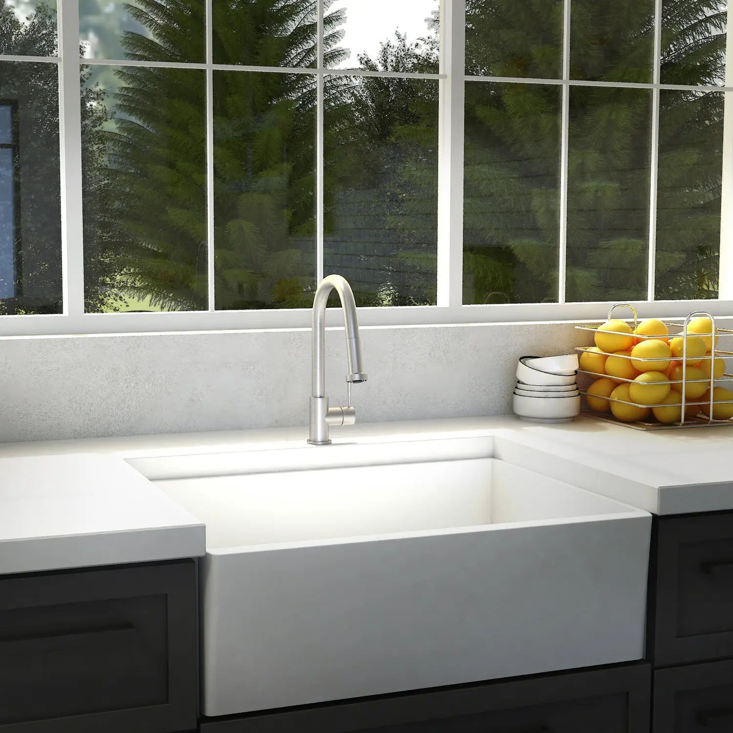 Modern kitchen sink beneath a window, with white counters, dark cabinets, and a bowl of lemons on the right.