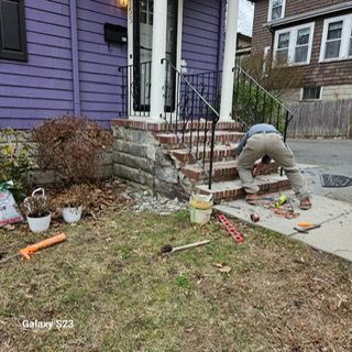 A man is working on a set of stairs in front of a purple house