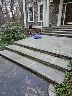 A man is working on the steps of a house