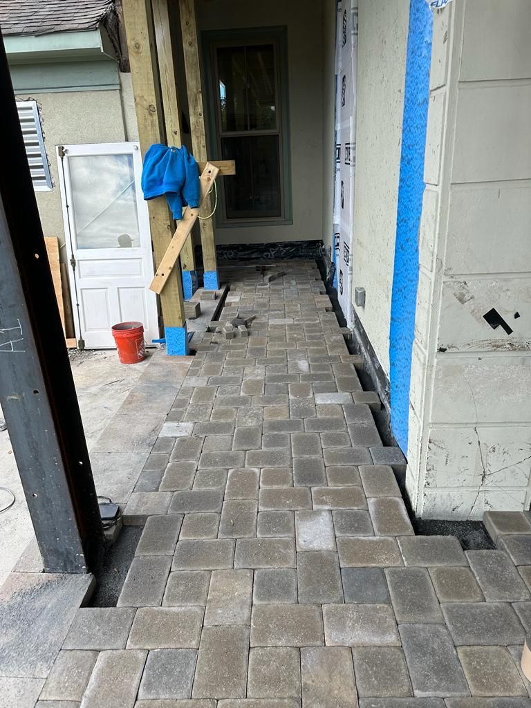 A brick walkway is being built in front of a house