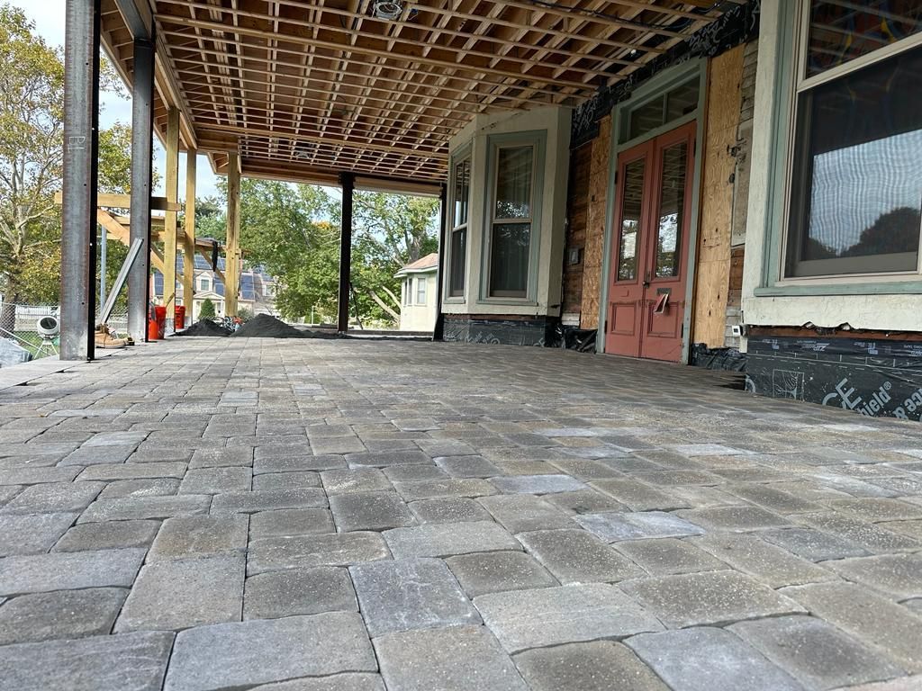 A brick walkway leading to a house under construction
