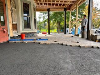 A man is standing in front of a house under construction