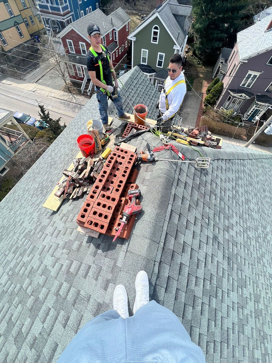 A group of men are standing on top of a roof