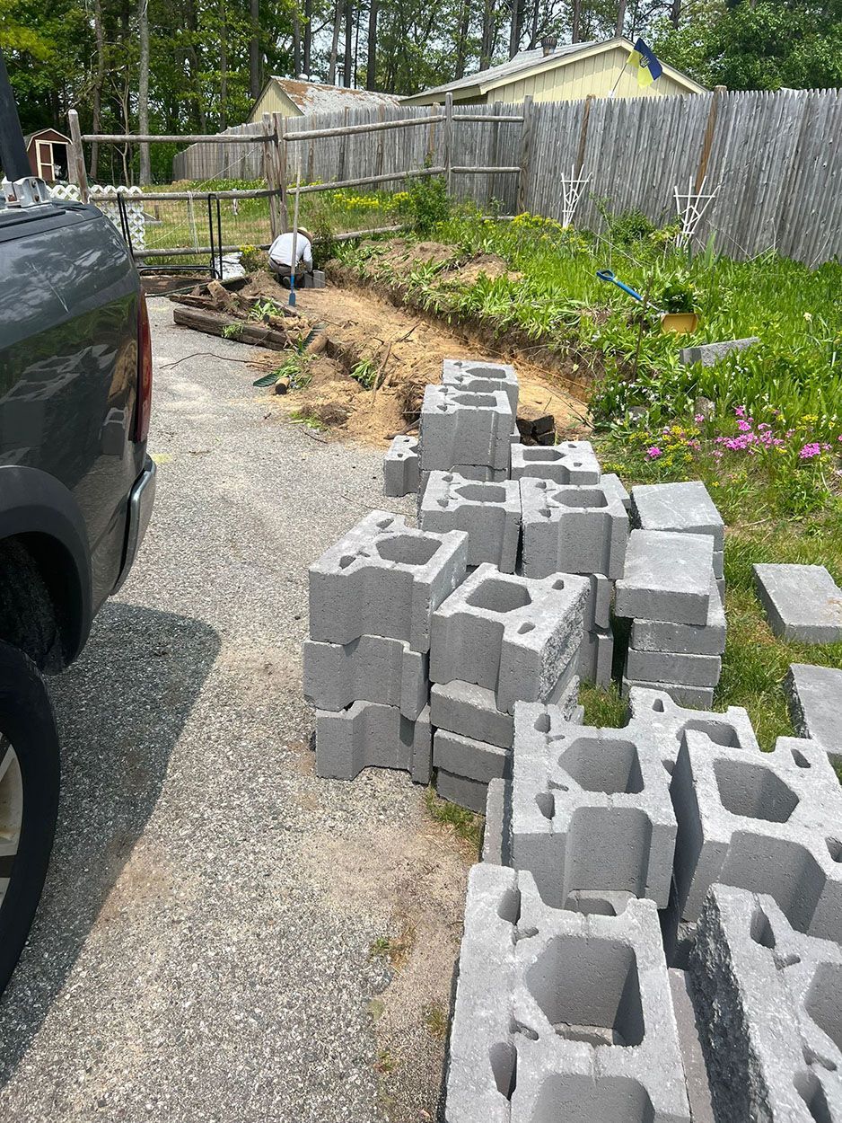 A truck is parked next to a pile of concrete blocks