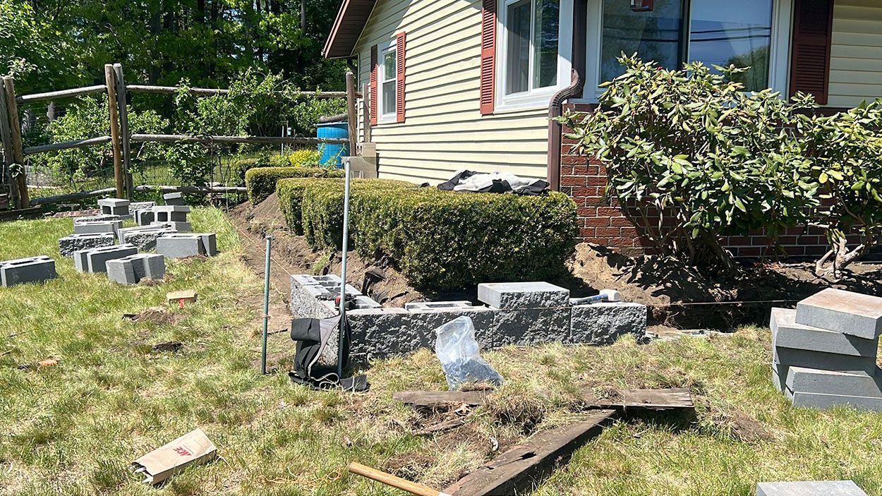 A retaining wall is being built in front of a house
