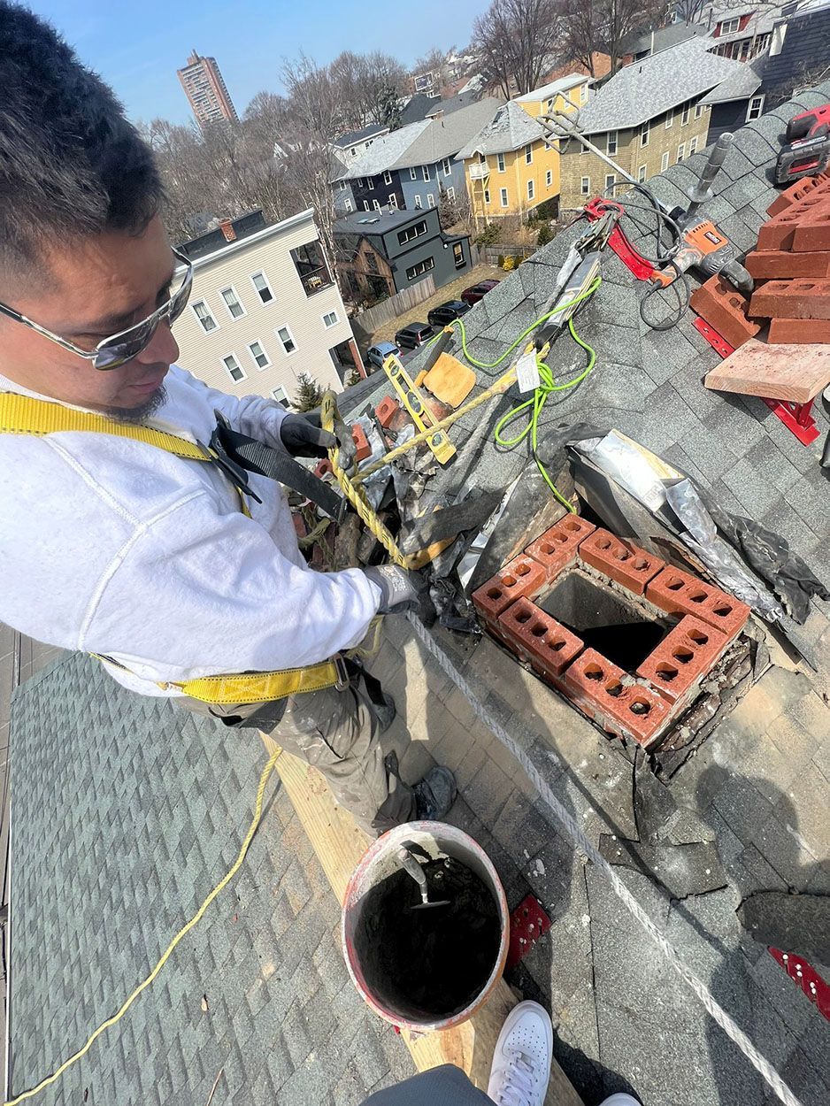 A man is working on a chimney on top of a roof