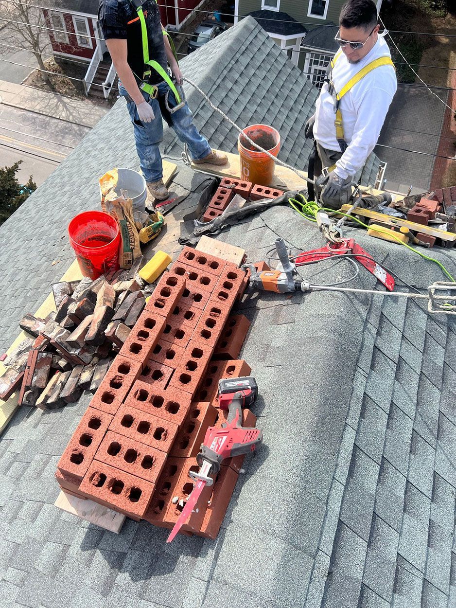 Two men are working on the roof of a house