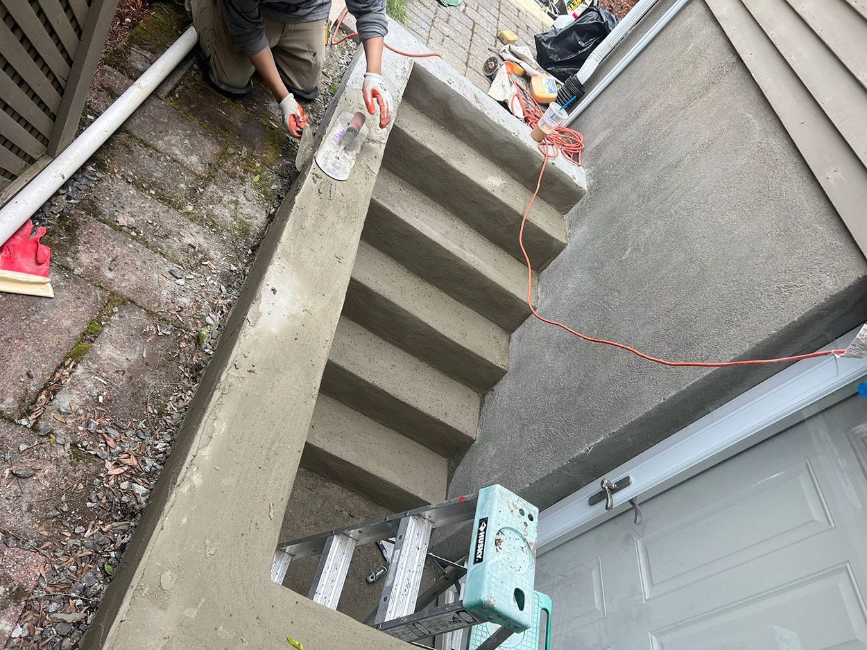 A man is working on a set of concrete stairs