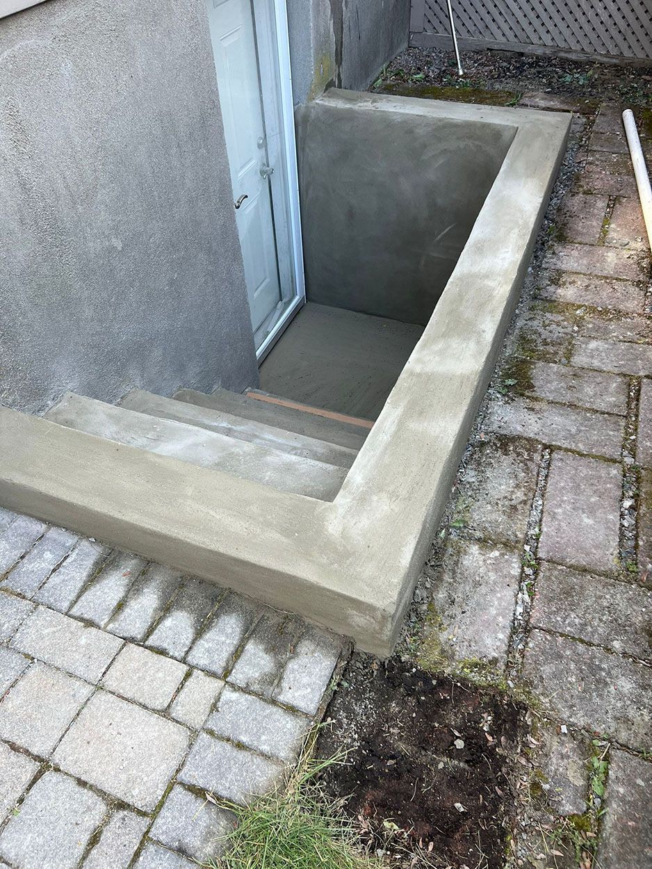 A concrete entrance to a basement with stairs leading up to it