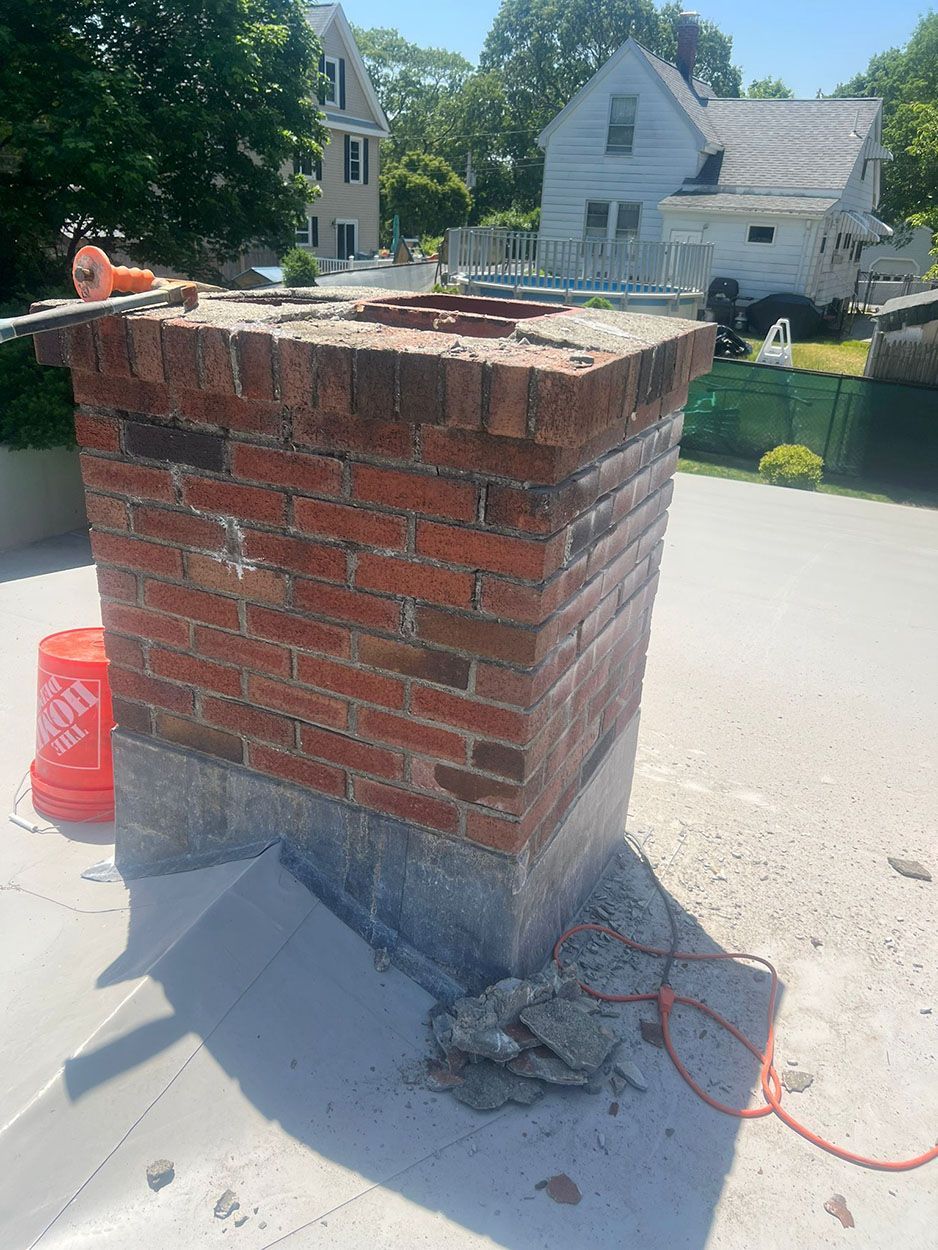 A brick chimney is sitting on top of a concrete surface