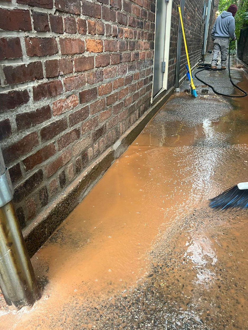 A man is cleaning a brick wall