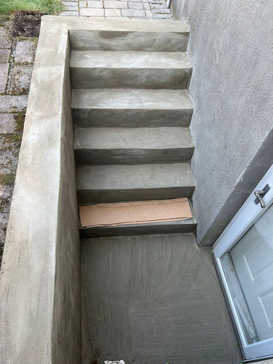 A set of concrete stairs leading up to a doorway