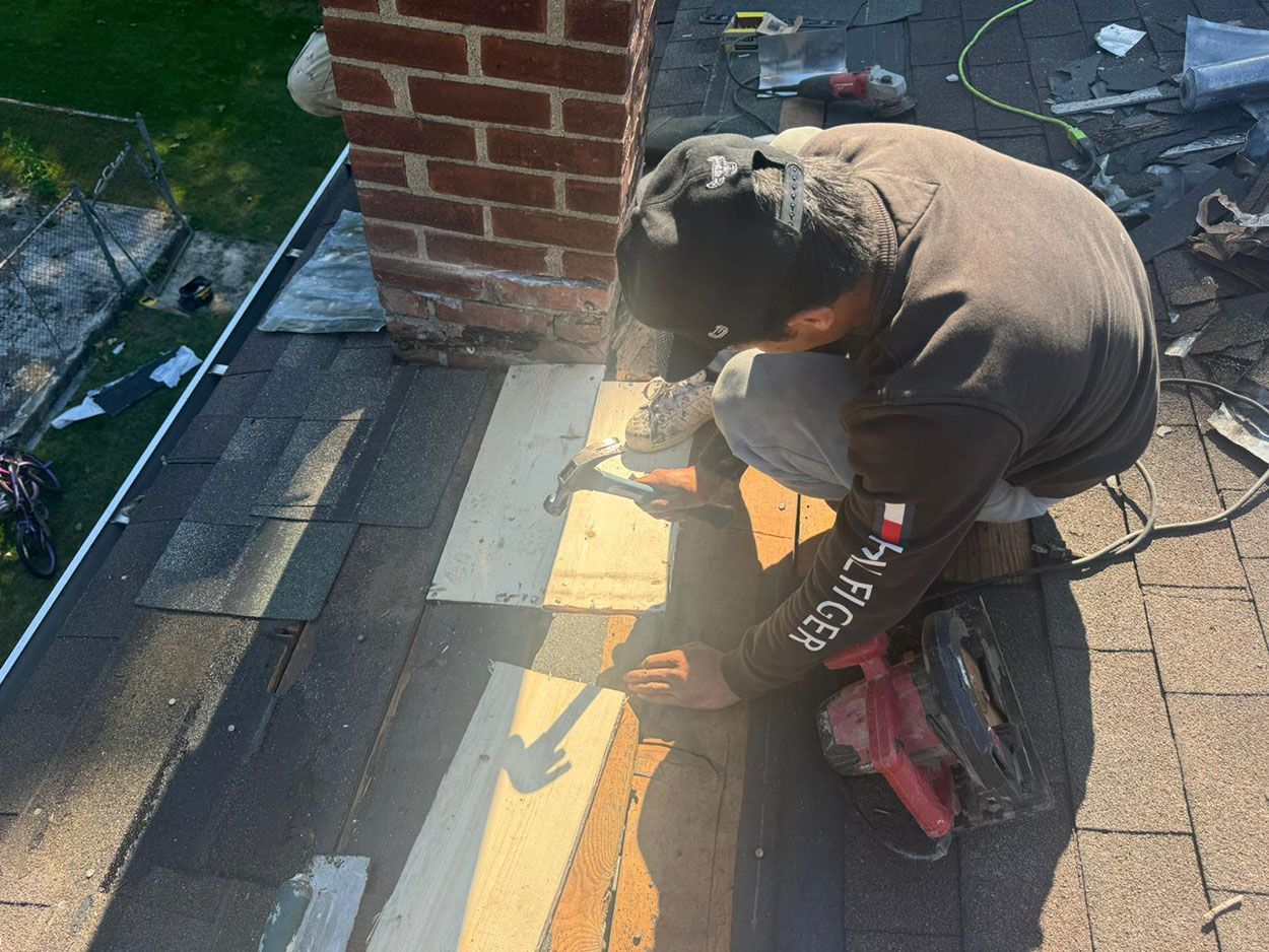 A man is working on a roof with a hammer