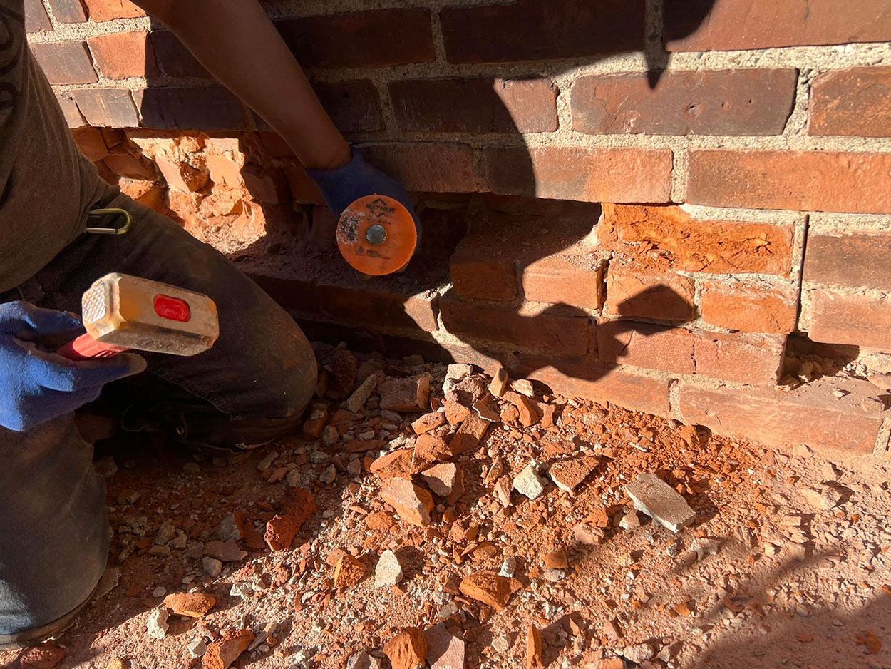 A person is removing the old brick wall.