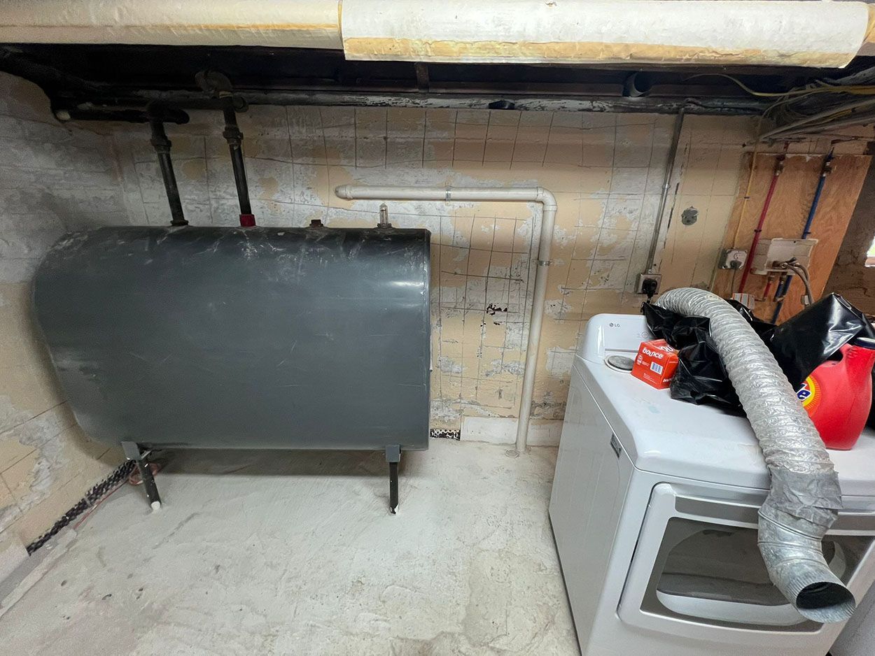 A laundry room with a washer and dryer and a large tank