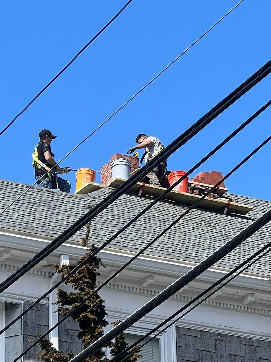 Two men are working on the roof of a house