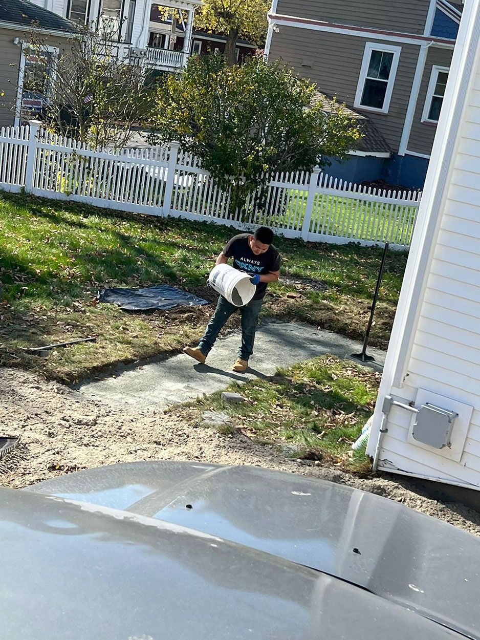 A man pouring cement on a walkway