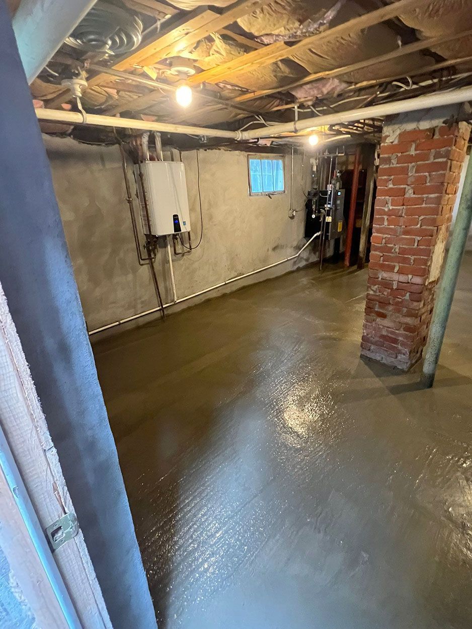A basement with a concrete floor and a brick post