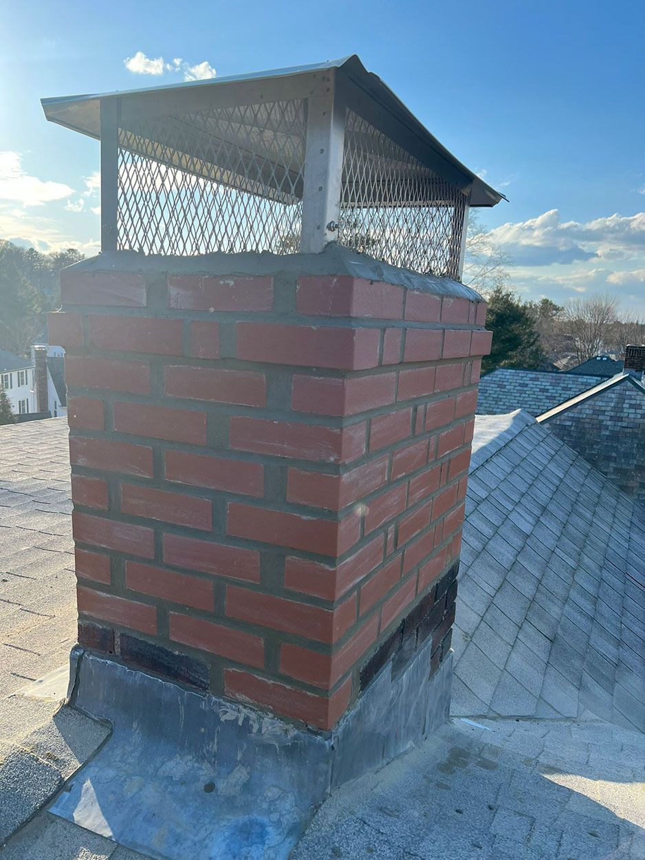 A brick chimney is sitting on top of a roof