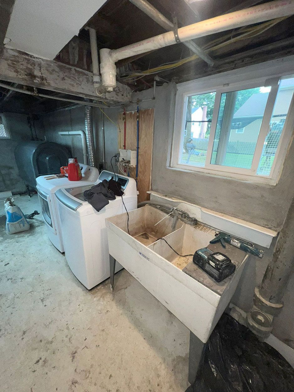 A laundry room with a washer and dryer and a sink