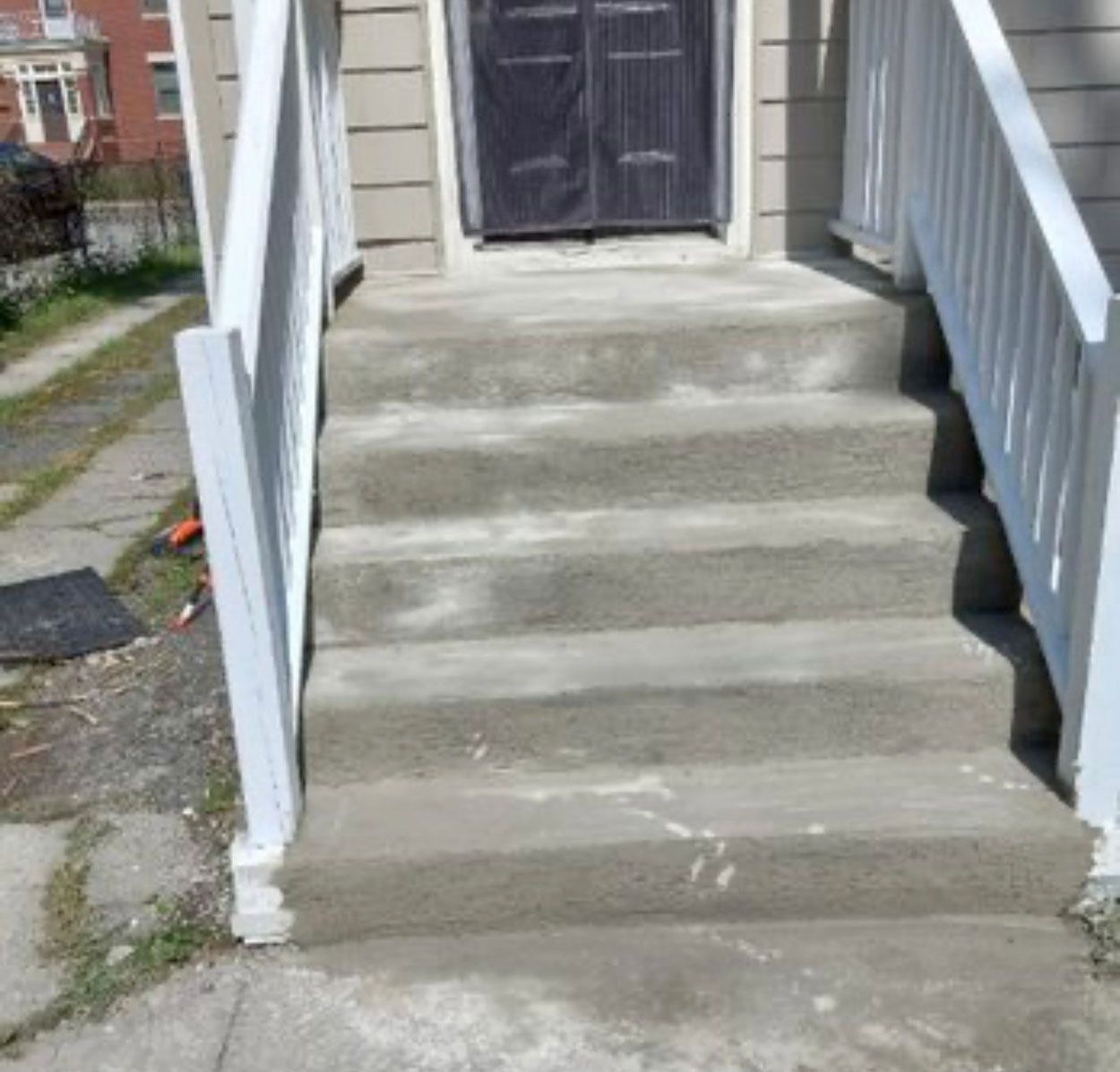 A set of stairs leading up to a door with a white railing