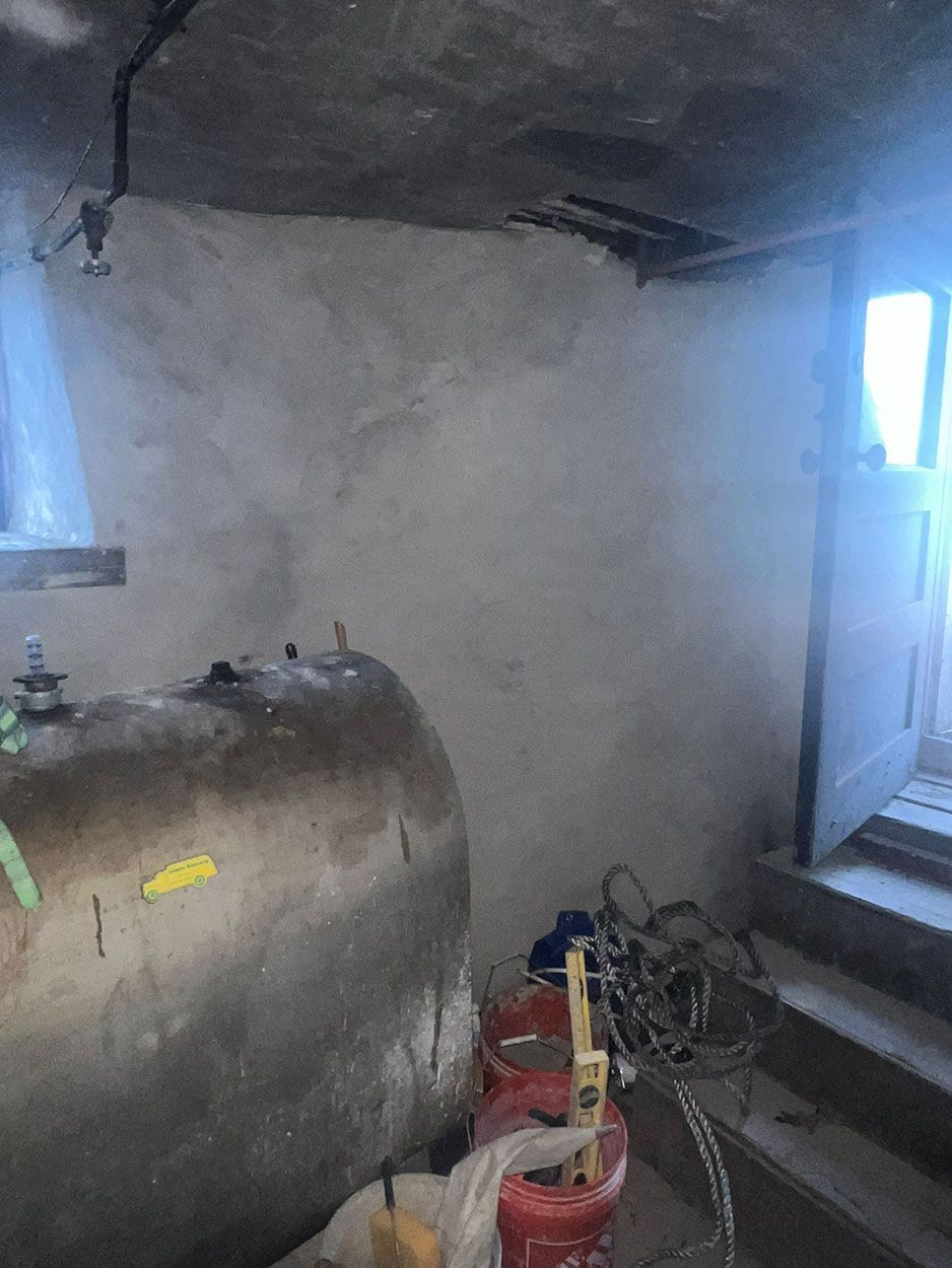 A large metal tank is sitting in a room next to stairs