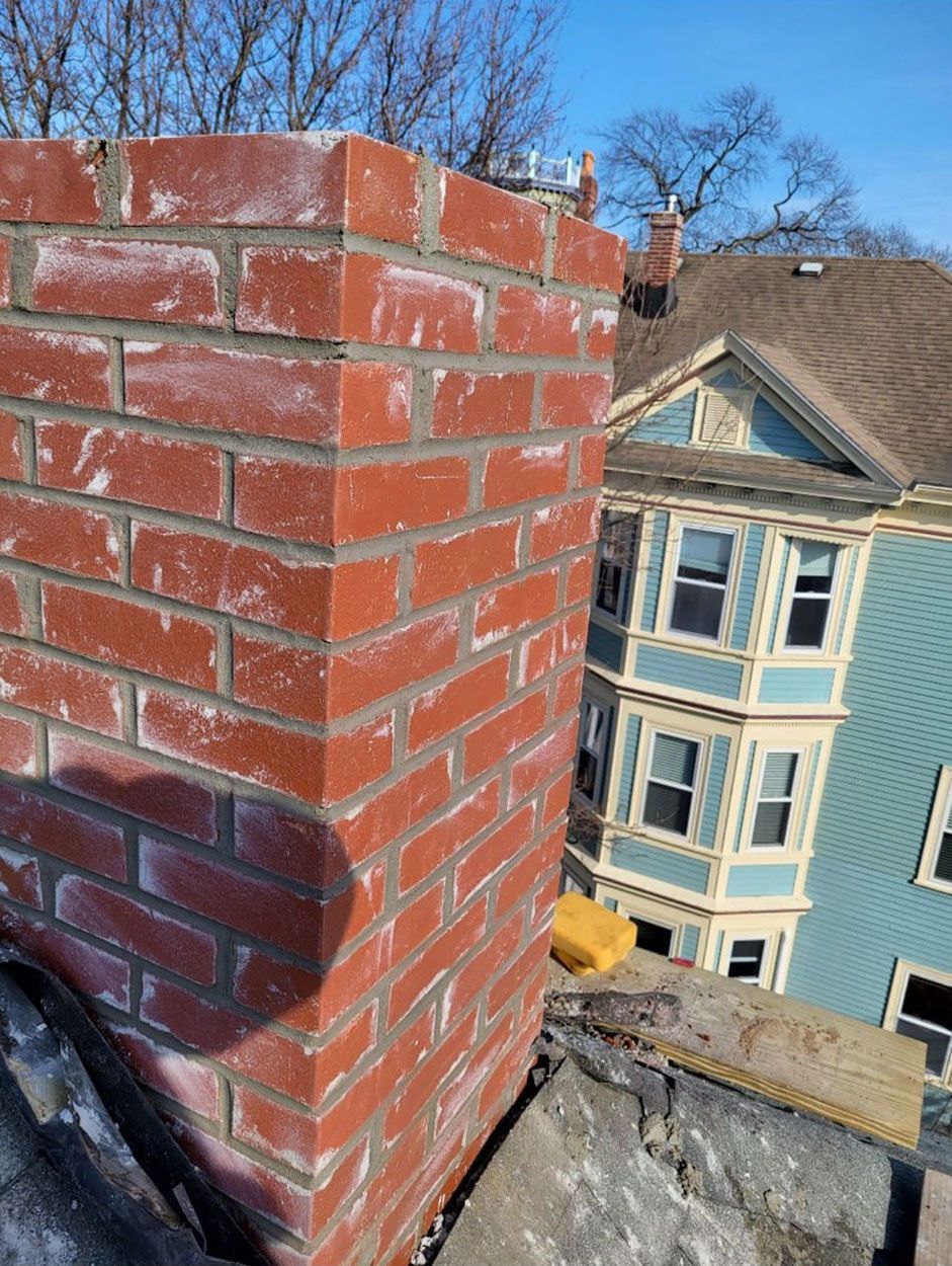A brick chimney is sitting on top of a roof