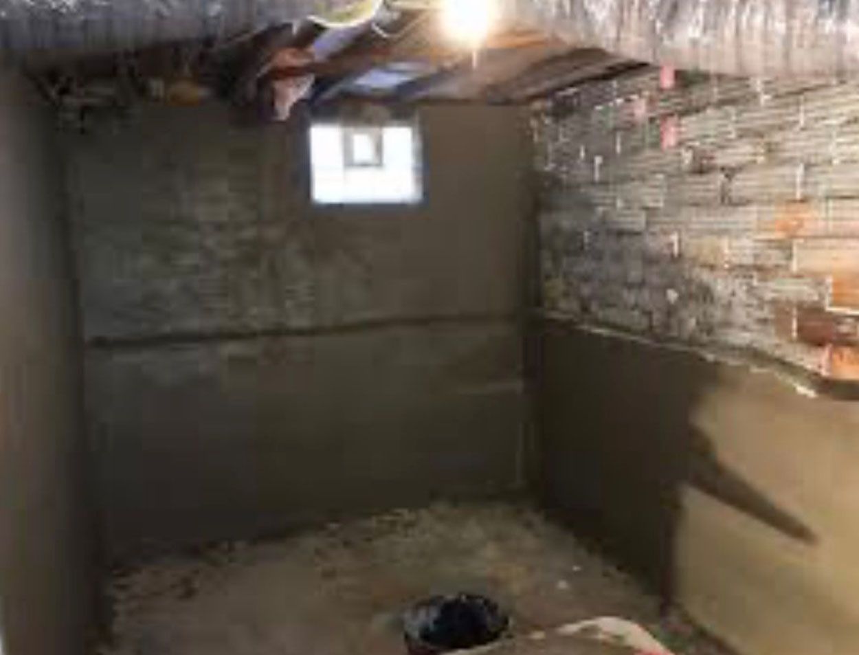A room with concrete wall and a window
