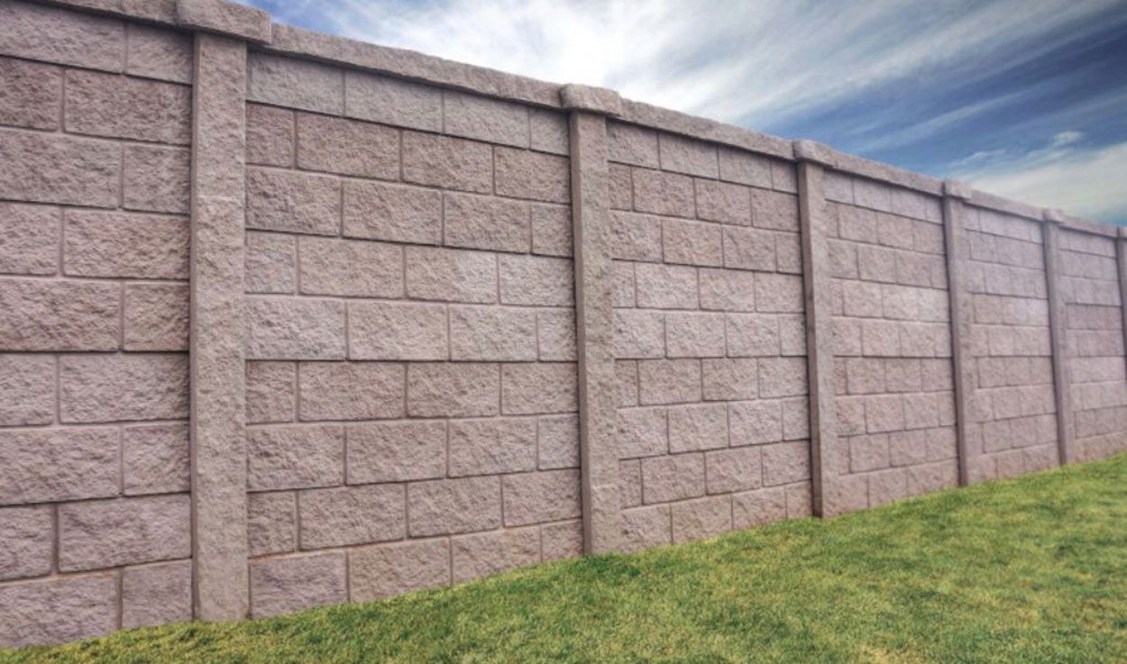 A retaining wall in the middle of a lush green field