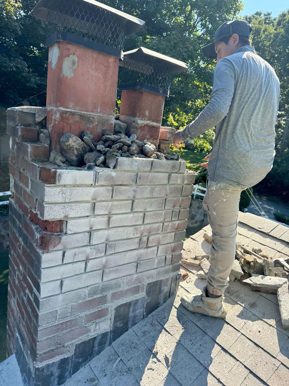 A man is working on a chimney on a roof