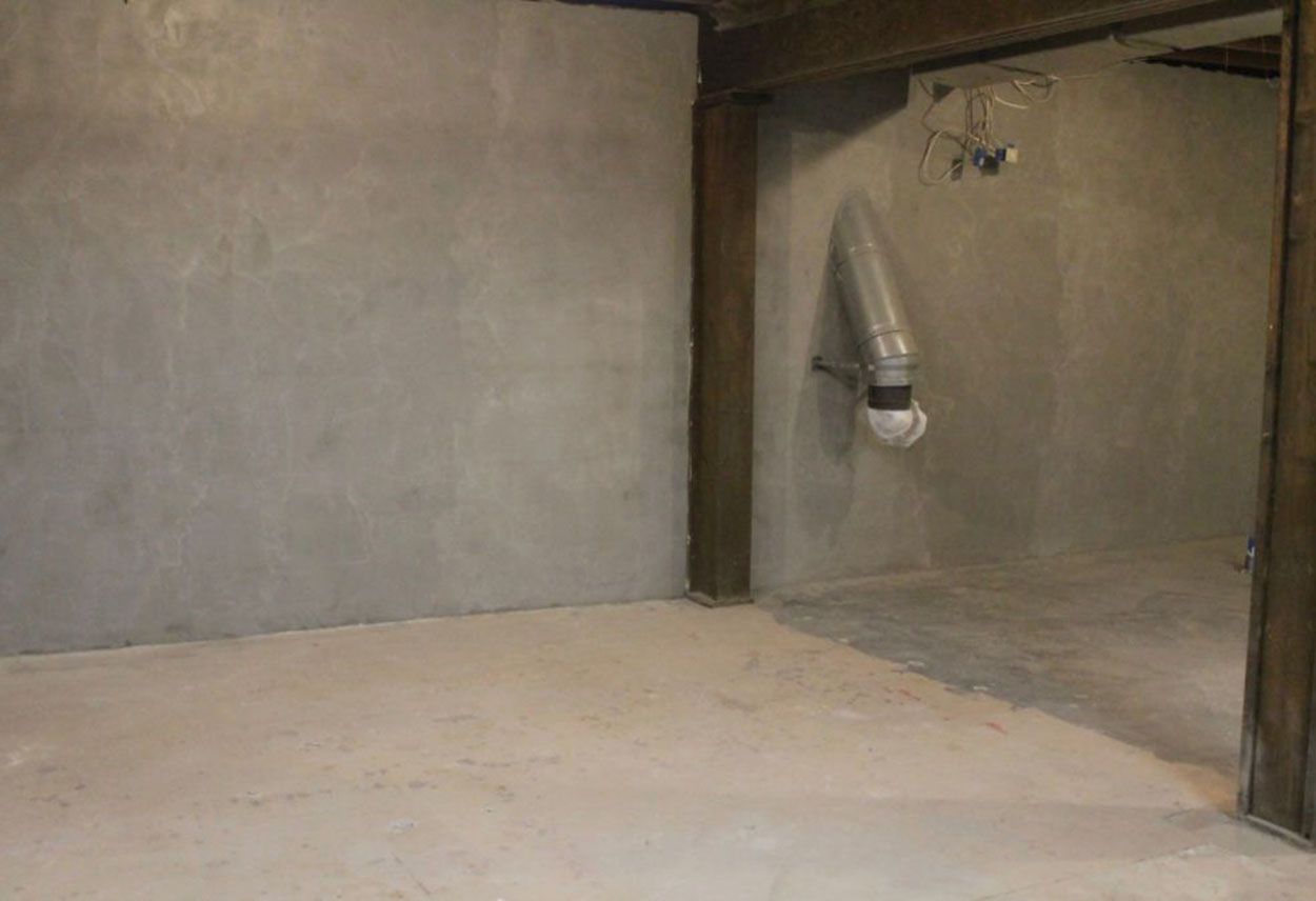 An empty room with a concrete floor and walls