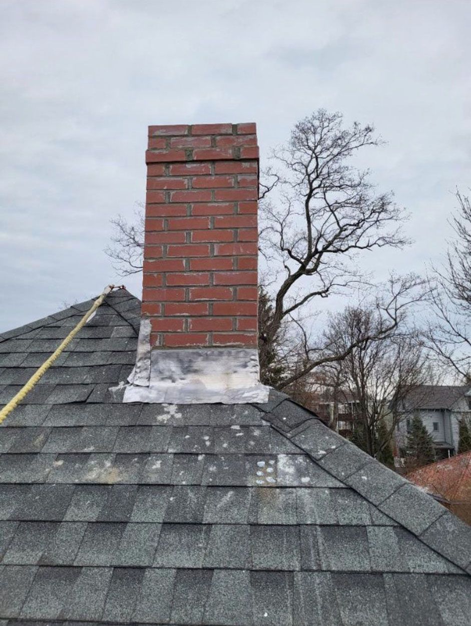 A newly repaired brick chimney on top of a roof