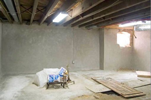 An empty basement with wooden beams and a chair on the floor.