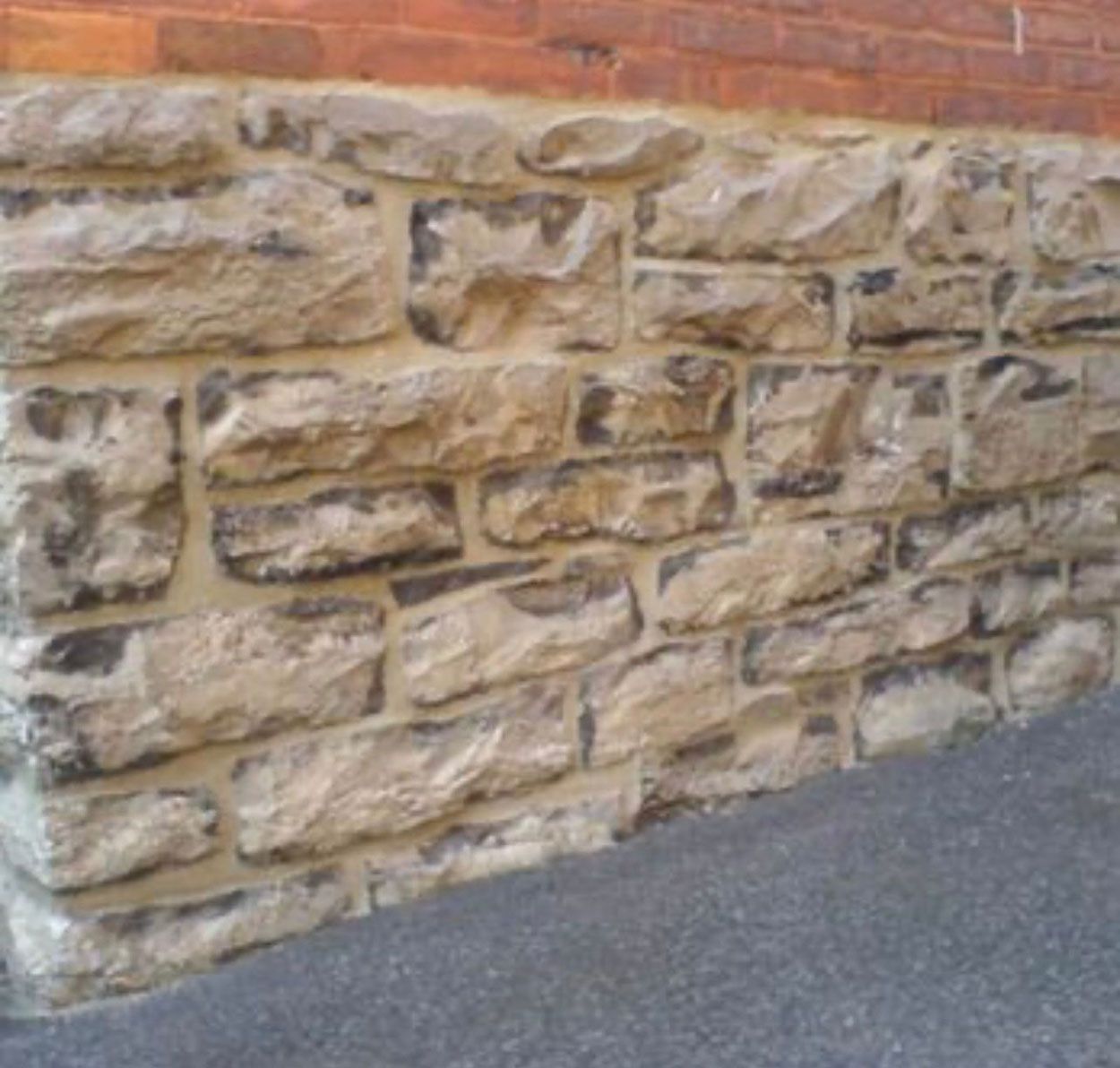 A brick wall with stone wall base