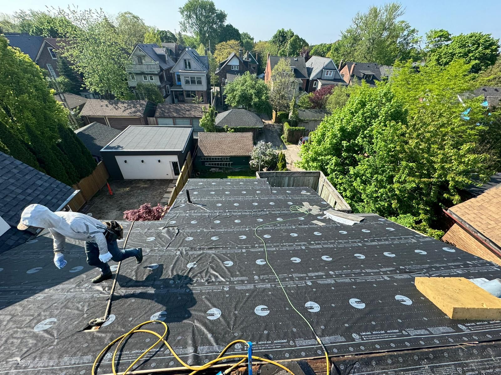 A man is working on the roof of a house.