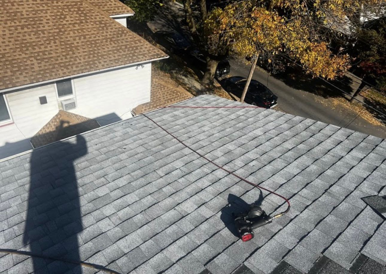 An aerial view of a roof with a shadow of a person on it.