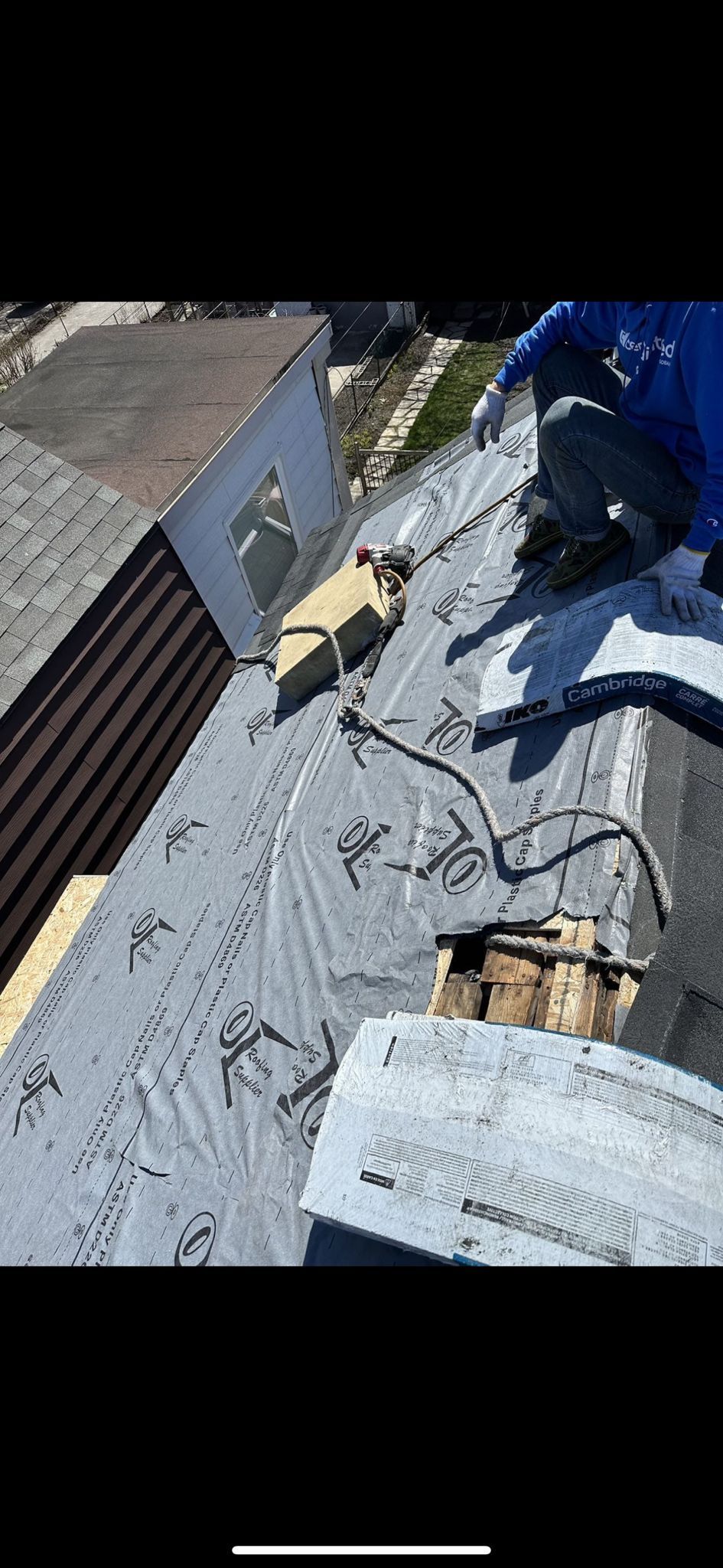 A man is working on the roof of a house.